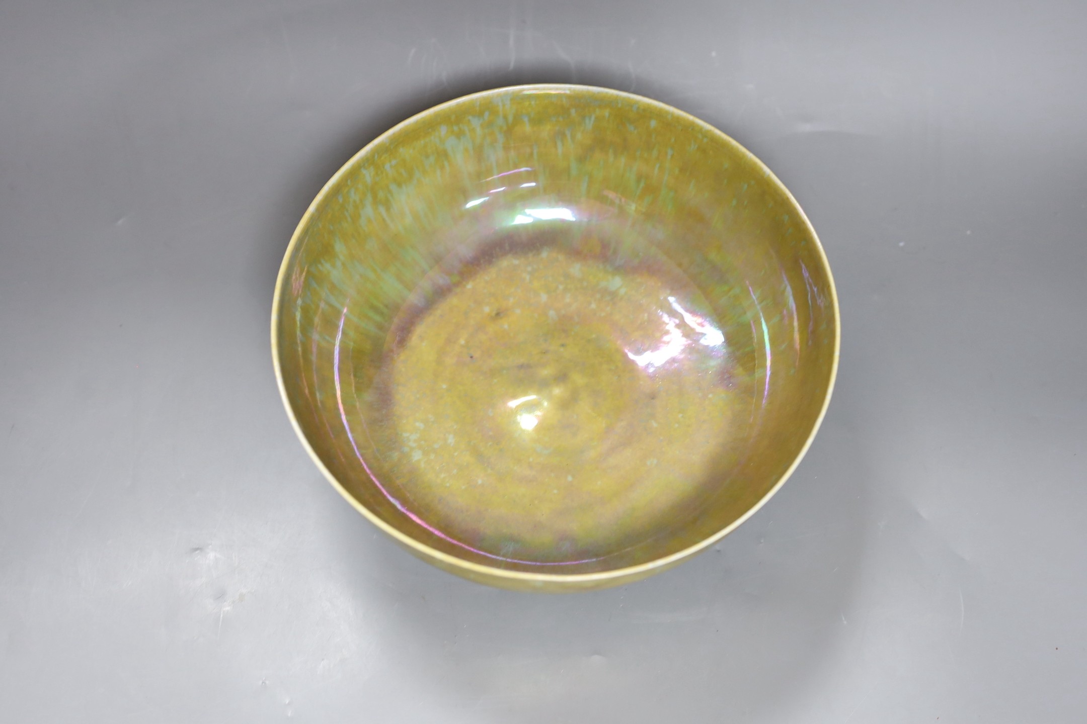 A Ruskin thinly potted green and ochre lustre fruit bowl, dated 1923, 25cm diameter